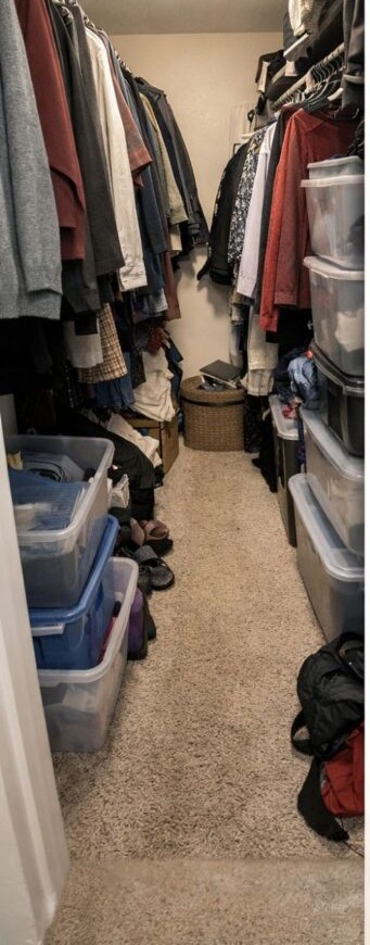 Closet before organization upgrade with crowded hanging clothes and stacked storage bins